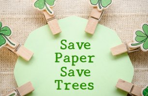 Save paper save trees on green paper and leaf wooden clamps on fabric background. Save world save life concept.