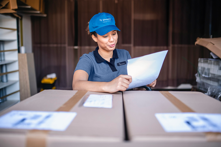 Close-up of mixed race woman in late 20s checking bill of lading while moonlighting on weekends as independent gig delivery driver., Picture